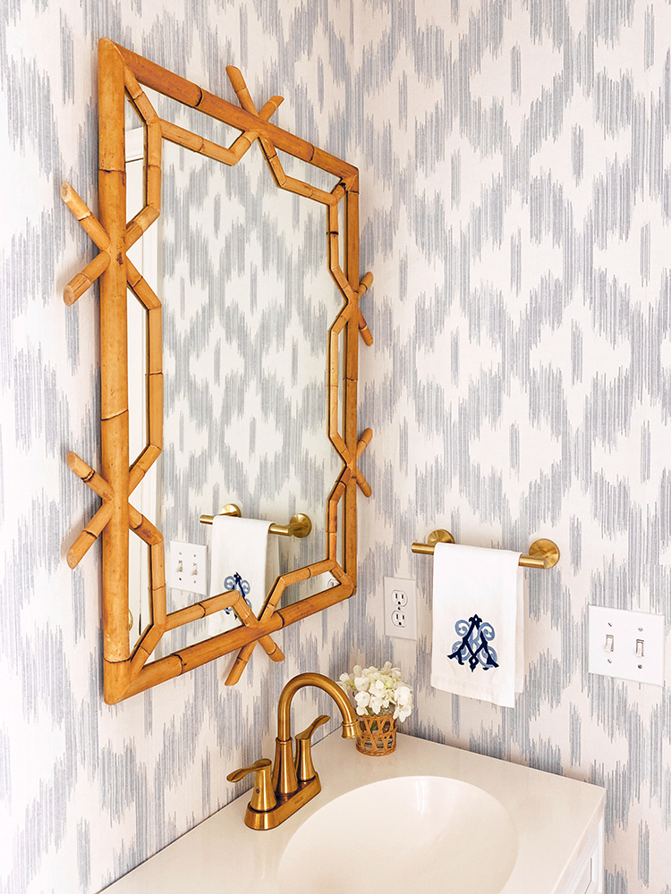 keller ogee blue ikat wallpaper, scalloped light, hermes scarf frame, serena and lily lanai mirror, bamboo mirror, blue and white powder room, bathroom renovation, monogrammed hand towel, amanda lindroth design woven hurricane glass